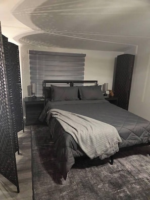 Ein Schlafzimmer mit einem Bett, Nachttischen und einem Beistelltisch.