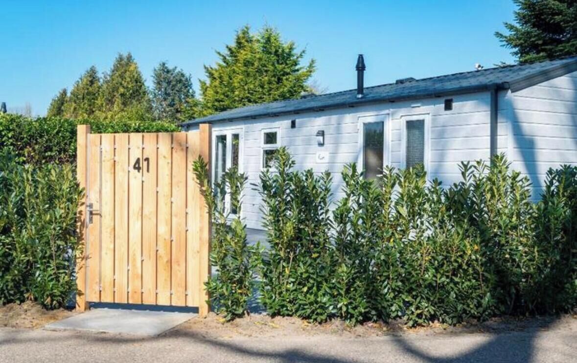 A mobile home with a wooden gate labeled '41' and a paved driveway.