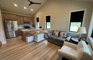 A modern kitchen with a central island, wooden cabinets, and stainless steel appliances. - New build cabin with AC on 20+ acres outside Custer (Custer)