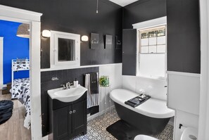A modern bathroom with a black and white color scheme, a double sink, a freestanding bathtub, and a window with a view. - Cozy Aberdeen MS Retreat Near Lake & MSU (Aberdeen)