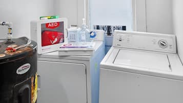 Zona de bugaderia amb dues rentadores, una sequadora i un desfibril·lador.