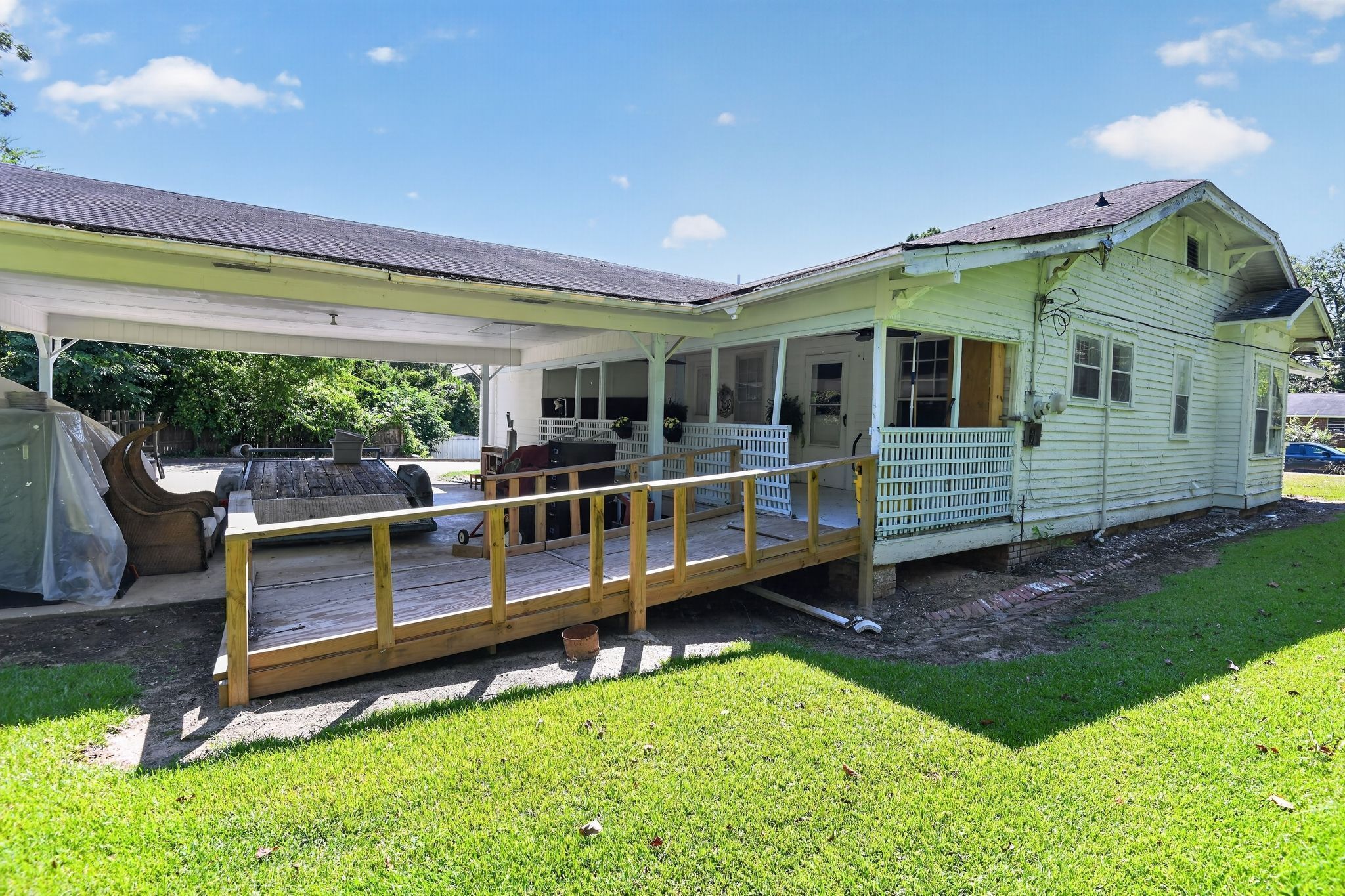 A two-story house with a covered porch and a wooden deck.