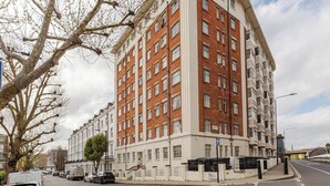 Un edificio de varios pisos con fachada de ladrillo, ventanas grandes y techo plano.