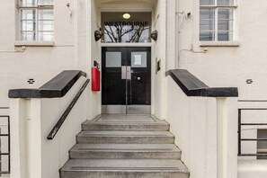 A staircase leading to a double door with the sign 'WESTBOURNE' above it. - Westbourne Court (London)