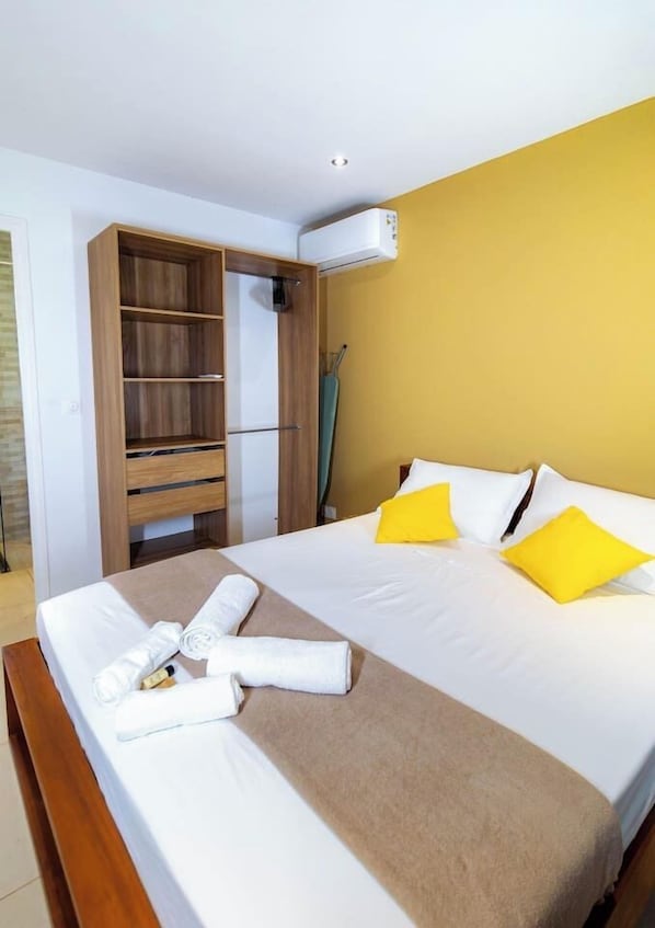 Ein Hotelzimmer mit einem Bett, einem Holzschrank und einer Klimaanlage.