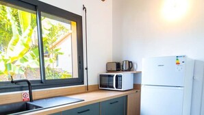 Cocina compacta con lavamanos, microondas y refrigerador.