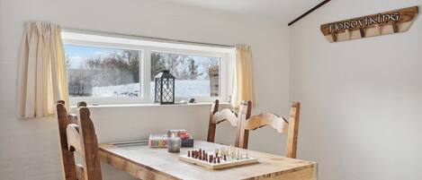 A room with a wooden table, chess set, and a BINGO box.