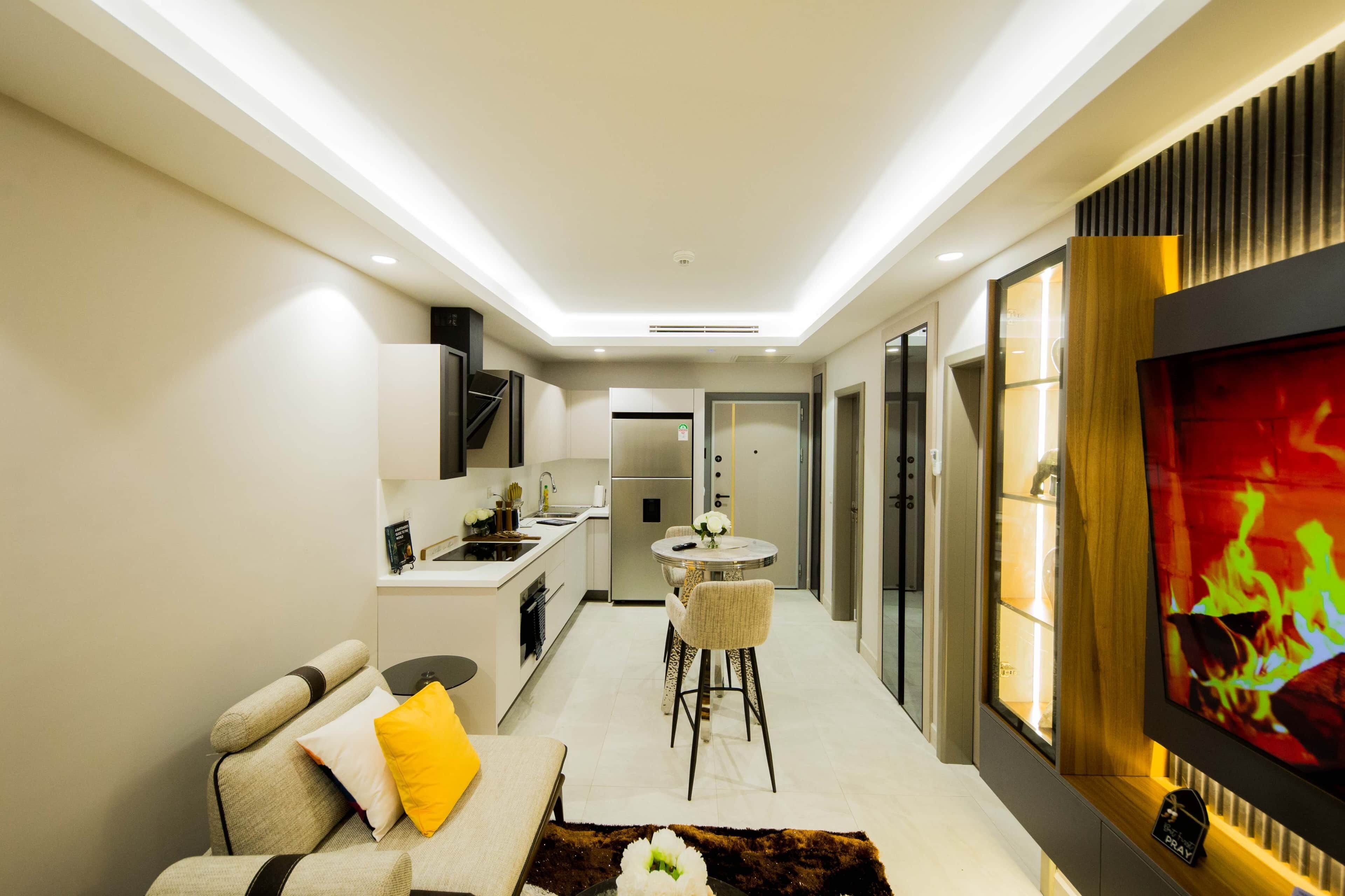 A modern living room with a sofa, a coffee table, and a TV mounted on the wall.