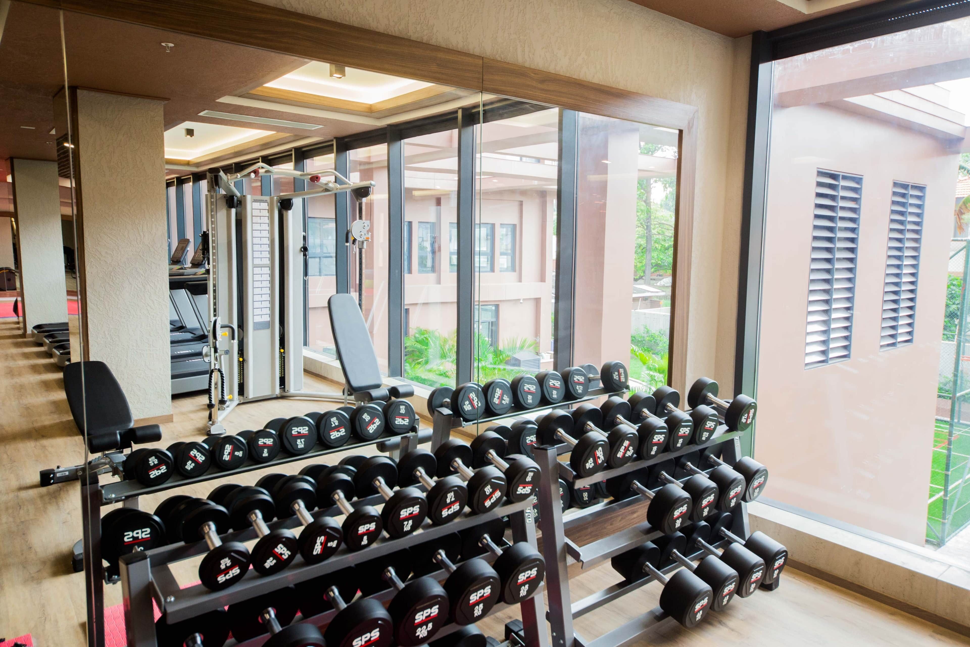 A gym with weightlifting equipment and a treadmill.