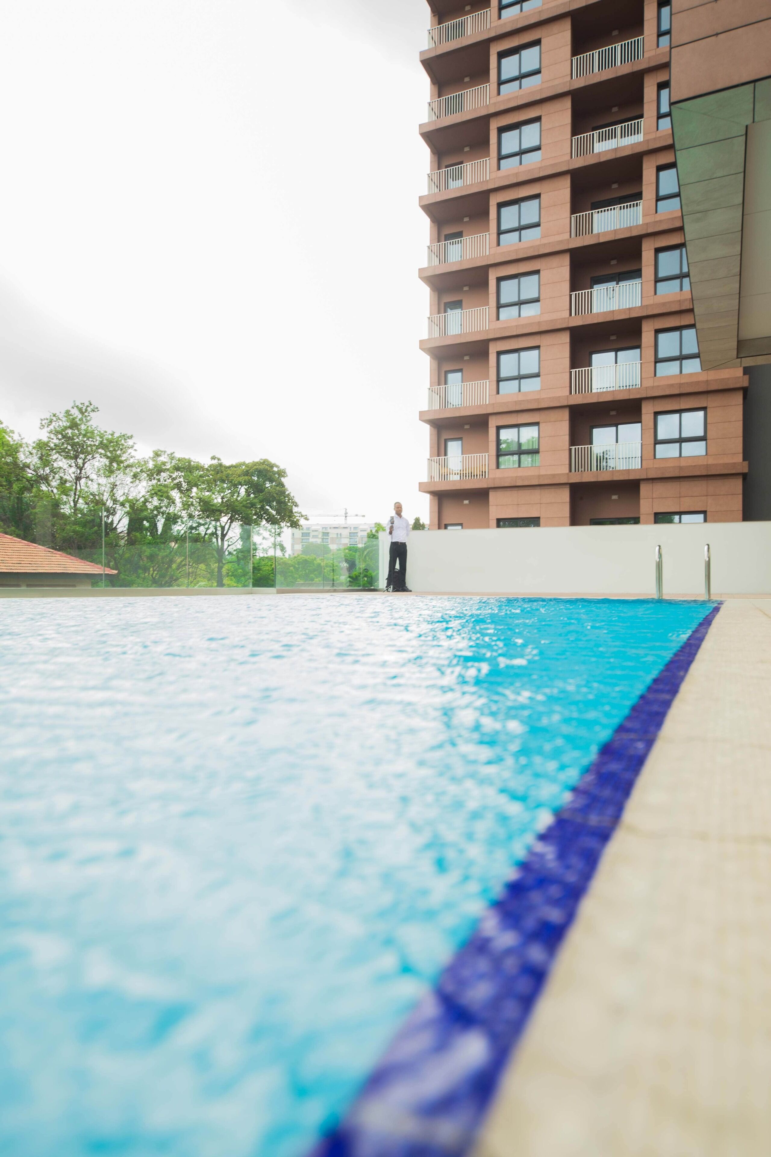 Uma piscina com uma pessoa parada na borda.