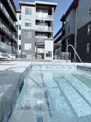 Ein modernes Gebäude mit Schwimmbad, Außenbereich und blauem Himmel.