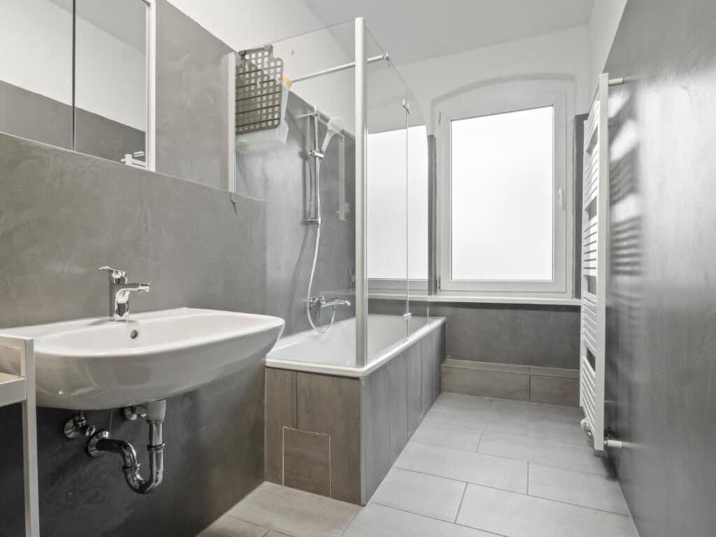 A modern bathroom with a sink, bathtub, and shower.