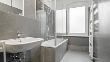 A modern bathroom with a sink, bathtub, and shower.