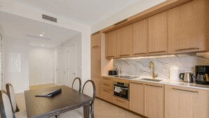 Una cocina moderna con armarios de madera, encimera de mármol y horno empotrado.