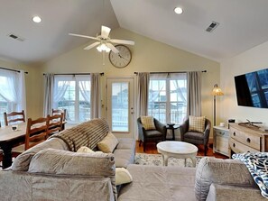 A room with a sofa, armchairs, a dining table, and a TV. - 4BR in Downtown Surf City • 1 Block to Beach (Surf City)