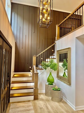 A staircase with wooden steps and a handrail, leading to a landing with a green vase and a mirror. - Serenity Lake House . Private Lakefront Escape (Trail Creek)