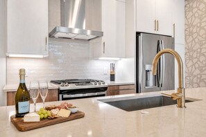 Chef's kitchen with island sink and gold fixtures, where the cook stays part of the group during a group dinner in Nashville - 4BR Nashville house sleeps 12, minutes to Broadway & downtown (Nashville)