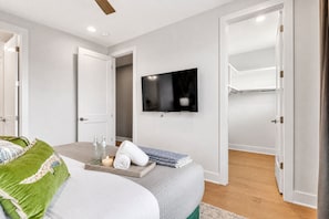 A modern bedroom with a bed, a TV mounted on the wall, and a walk-in closet. - 4BR Nashville house sleeps 12, minutes to Broadway & downtown (Nashville)