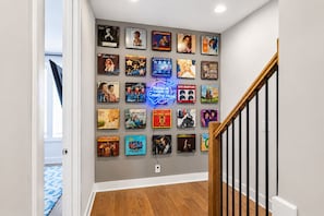 A hallway with a wall decorated with various album covers. - Rooftop deck townhome sleeps 12, minutes to Broadway, Nashville (Nashville)