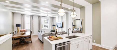 Una cocina moderna con una isla central, electrodomésticos de acero inoxidable e iluminación colgante.