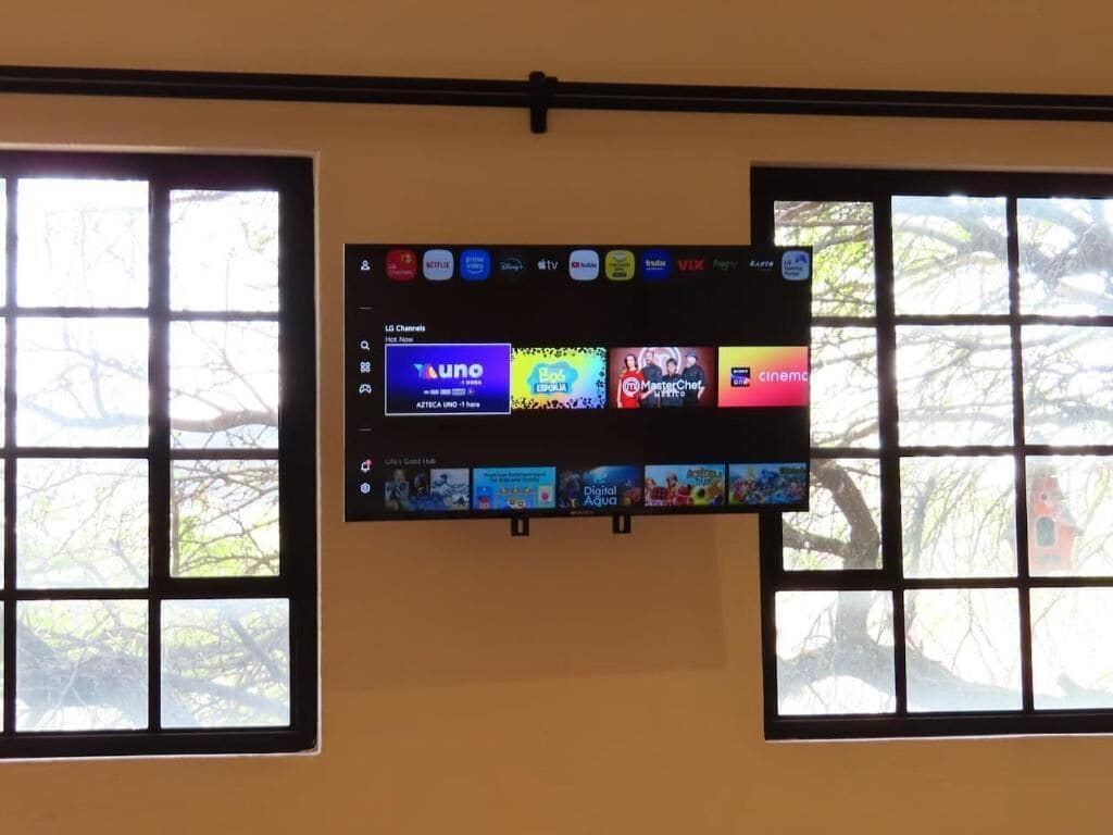 Un televisor de pantalla plana montado en la pared con acceso a servicios de streaming.