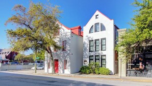 A white building with a red roof, a red door, and a large window. - Walk to Charleston’s Best Dining and Entertainment (Charleston)