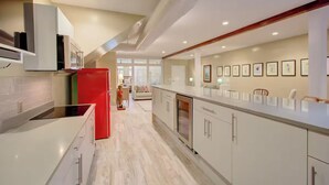 A modern kitchen with white cabinetry, a red refrigerator, and a built-in oven. - Walk to Charleston’s Best Dining and Entertainment (Charleston)