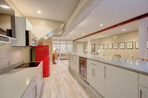 A modern kitchen with white cabinetry, a red refrigerator, and a built-in oven. - Walk to Charleston’s Best Dining and Entertainment (Charleston)
