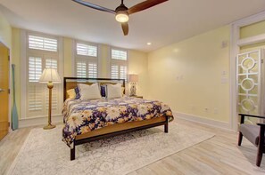 A bedroom with a bed, two bedside lamps, a ceiling fan, and a window with blinds. - Walk to Charleston’s Best Dining and Entertainment (Charleston)