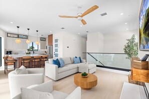 Ein stilvolles Wohnzimmer mit Sofa, Couchtisch und Blick auf die Küche.