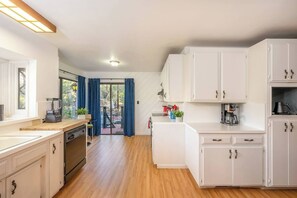 A modern kitchen with white cabinets, a coffee maker, and a blender. - Sierra Haus | 4mi to Sequoia + Hot Tub + Game Room (Three Rivers)