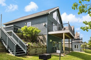 A two-story house with a balcony, a staircase, and a small garden area.