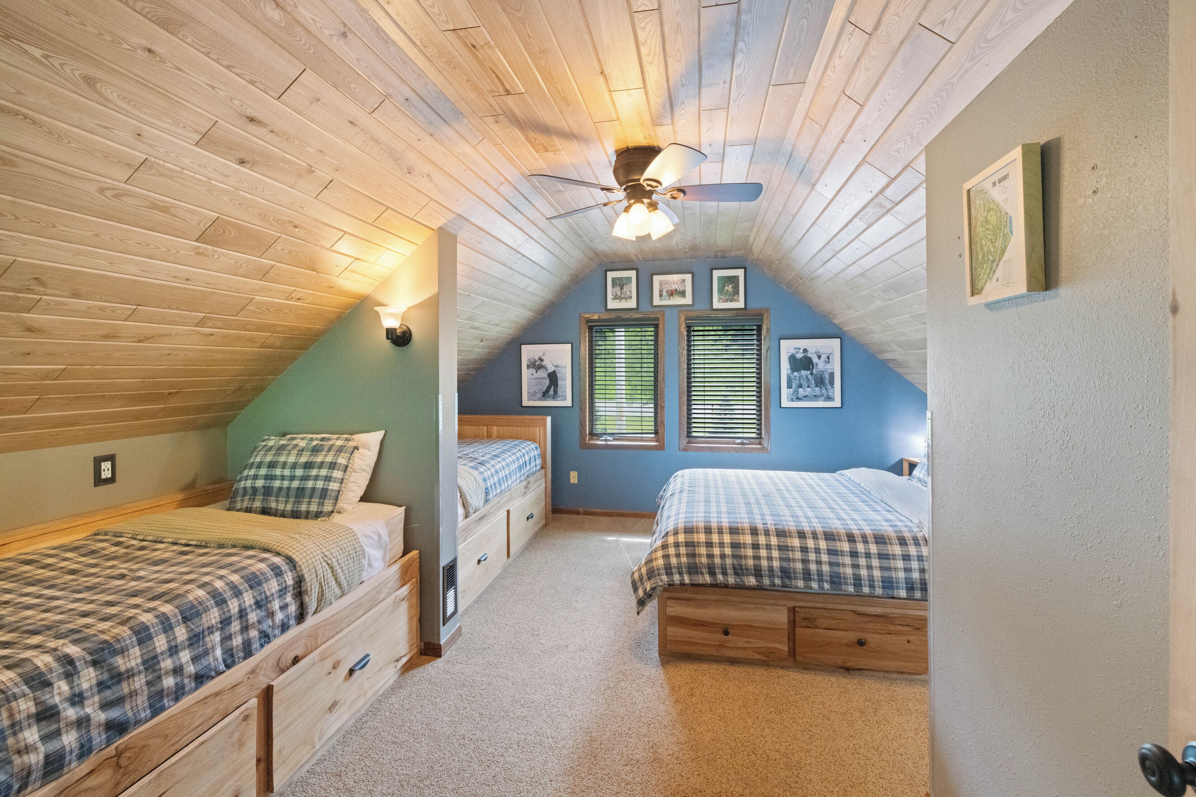 Ein Schlafzimmer mit zwei Betten, Holzboden und Deckenventilator.