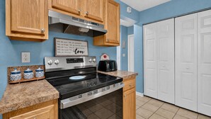 Una cocina con armarios de madera, estufa de acero inoxidable y un tostador.