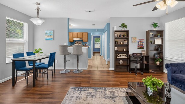 Un espacio habitable moderno con comedor, cocina y una zona de estar con un sofá azul y una mesita de centro.