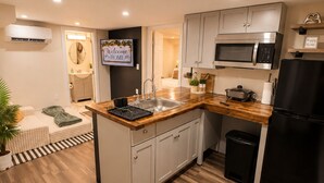 A modern kitchen with a central island, built-in appliances, and a view into the living area.