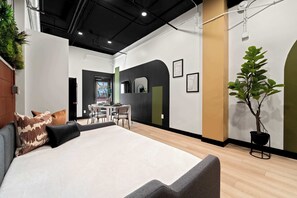 A modern interior with a bed, seating area, dining table, and potted plants. - Explore Petco Park & Gaslamp Nightlife - Sleeps 4! (San Diego)