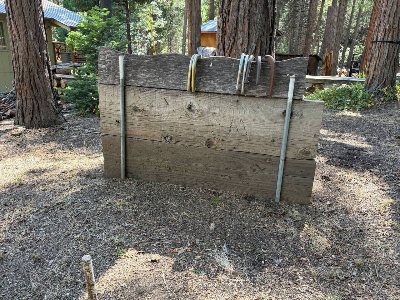A wooden structure with metal bars, surrounded by trees.