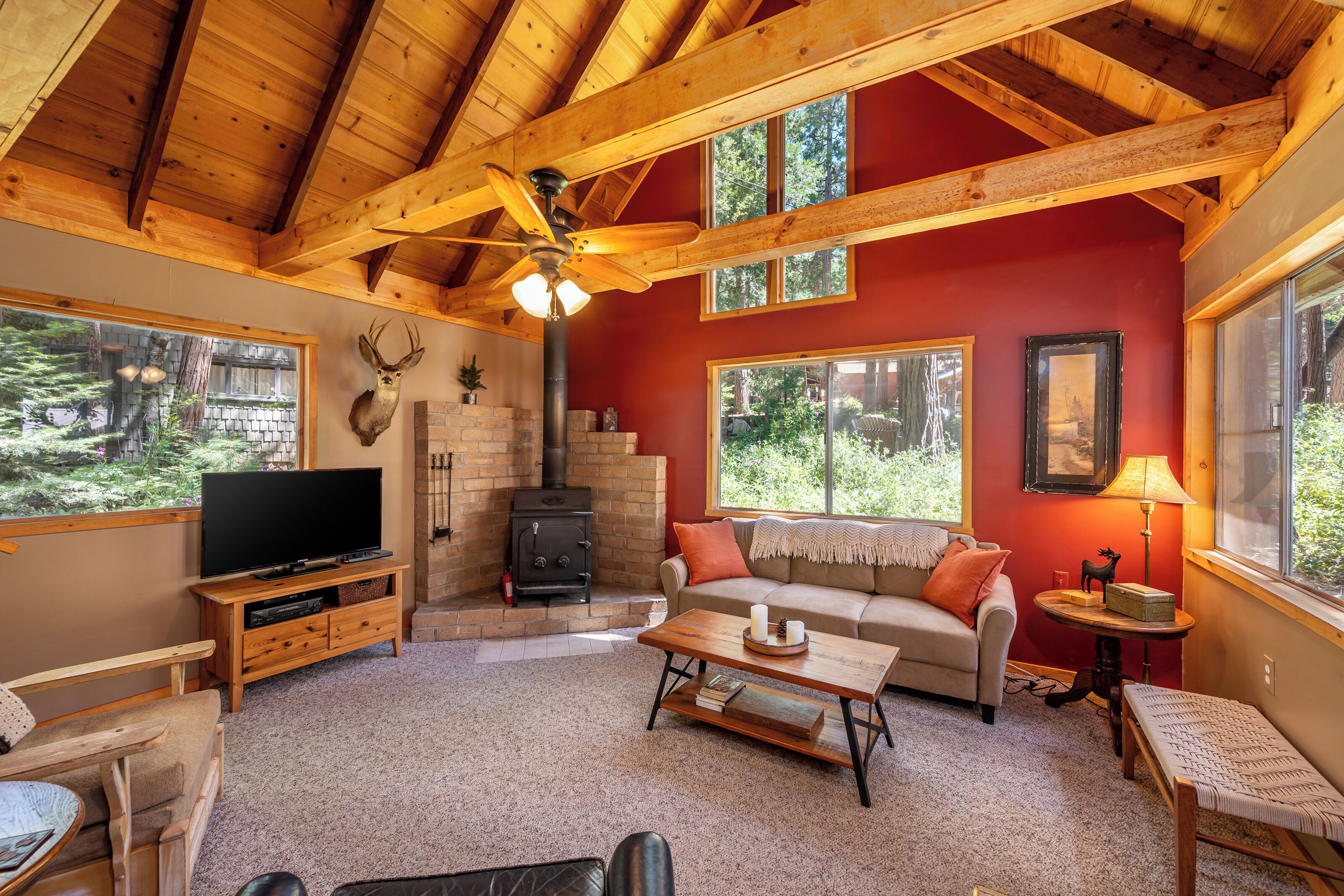 A cozy living room with a television, sofa, coffee table, and fireplace.