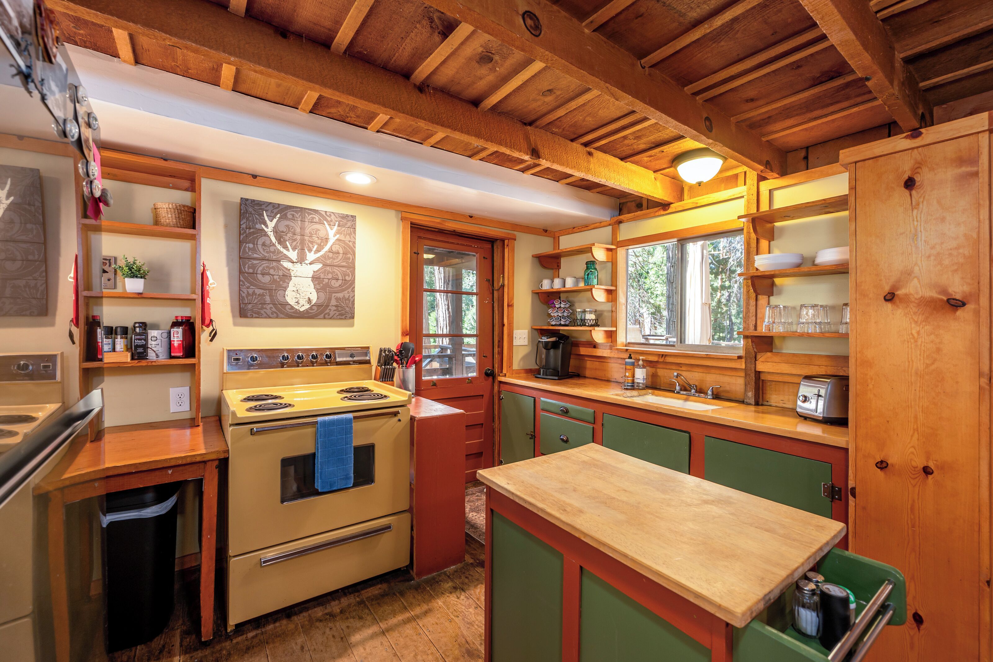 A kitchen with wooden cabinets, a stove, and a window.