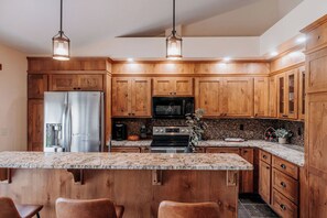 A kitchen with wooden cabinets, stainless steel appliances, and a granite countertop.