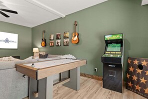 Ett rum med ett biljardbord, en vägg full med gitarrer och en spelkonsol.