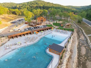 A resort with a large swimming pool, outdoor seating areas, and a parking lot. - Grand Ole Cabin has Arcades_Air Hockey_Peaceful View_Pvt Hot Tub_Near Pool & Lazy River (Hollister)
