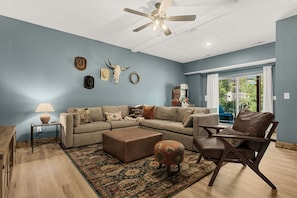 A living room with a sectional sofa, ottoman, coffee table, and a patterned rug. - Yellowstone Cabin w Arcades_Air Hockey_Pvt Hot Tub_Great Community Amenities (Hollister)