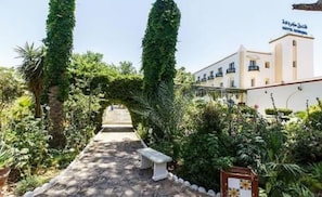 Un sendero que conduce a un edificio con un cartel que indica un hotel.