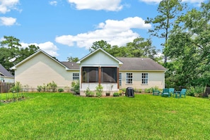 A two-story house with a covered patio, a fenced yard, and a satellite dish. - Sweetgrass Cottage, Pond Views, Pet Friendly, Boat Trailer Parking & Fireplace (Georgetown)