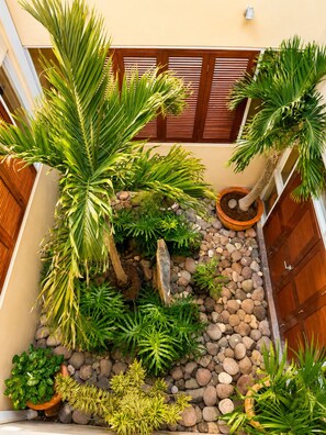 A courtyard with various potted plants, a stone pathway, and a wooden fence. - Luxury 5-bed, 5-bath with AC, pool, beach, hot tub, butler, chef, golf, sea view (Montego Bay)