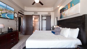 A hotel room with a large bed, a TV, a desk with a lamp, and a painting on the wall. - Las Palomas Phase II Coronado 506 Exceptional Oceanfront 2BR 2BA Unit. (Puerto Peñasco)