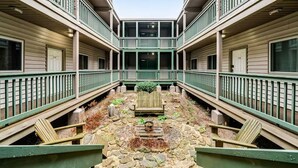 A courtyard with a central seating area, surrounded by balconies with railings.