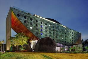 A modern building with a unique angular design, featuring a large overhanging structure and circular windows. - Premium Apartment - 500 meters from Ibirapuera Park: Comfort, swimming pool, free parking, and recreational activities. (São Paulo)